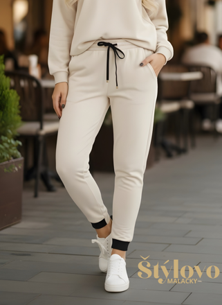 Dámske smotanové tepláky s čiernou šnúrkou.